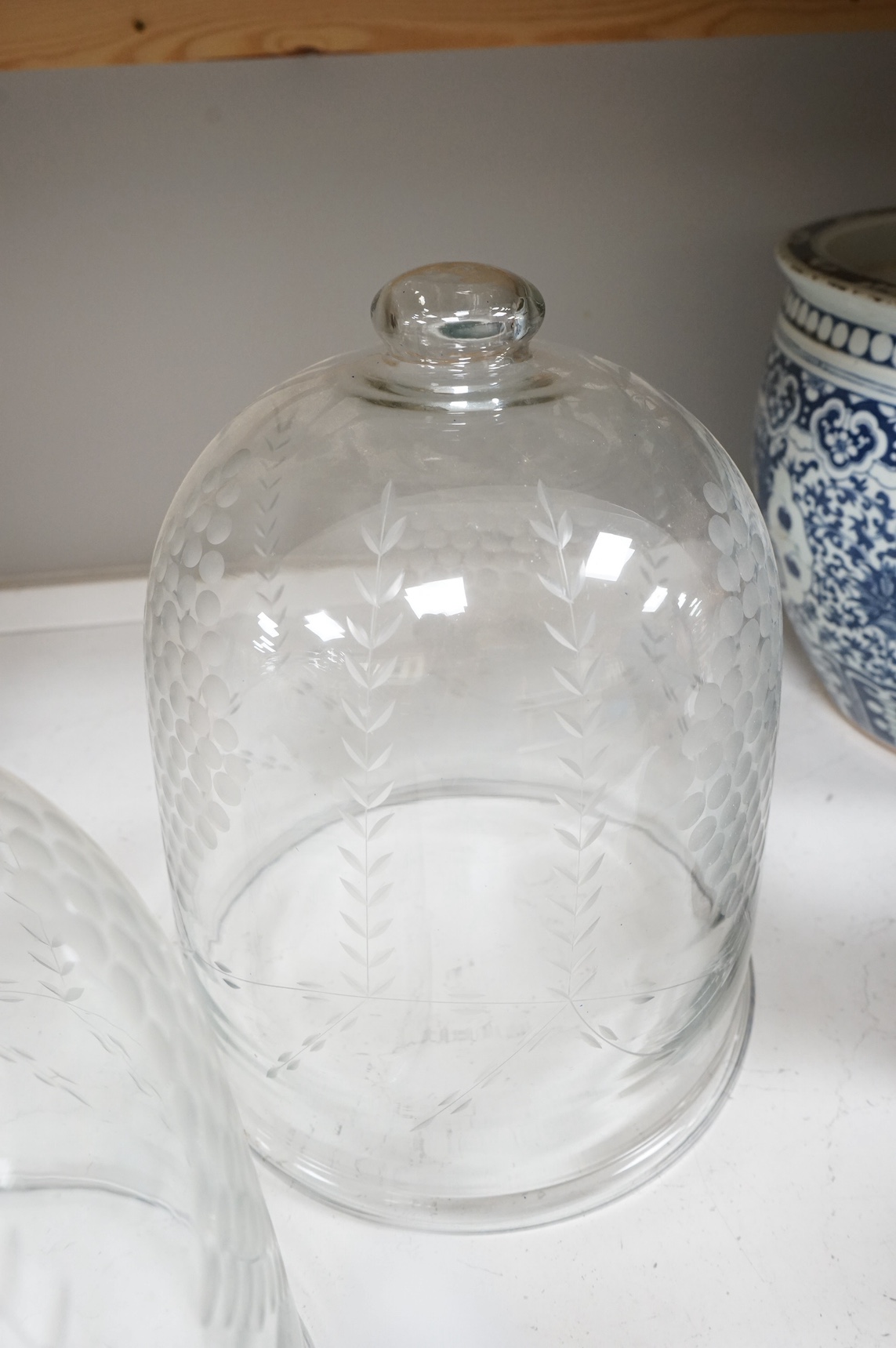 A pair of continental glass engraved cheese domes, 37cm high. Condition - good